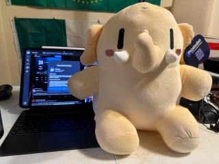 My Mastodon Plushie sitting in front of my iPad Pro 13 on a desk.