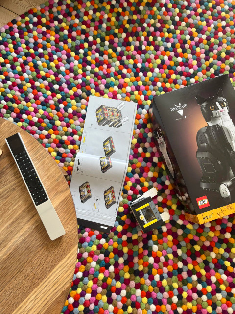 Lego Tuxedo Cat box, instruction box and the partially assembled set on a colourful carpet.