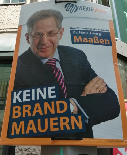 Ein Bild von einem Plakat der Werteunion, einer ehemaligen Unterorganisation der CDU mit dem Vorsitzenden Hans-Georg Maaßen. Das Plakat zeigt Maaßen und die Überschrift lautet „KEINE BRANDMAUERN. Ihre Stimme für die Freiheit!”