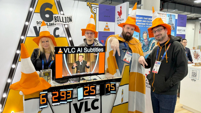 The VLC staff at their CES booth, wearing orange and white traffic cone wizard hats, and in one case a matching cape.