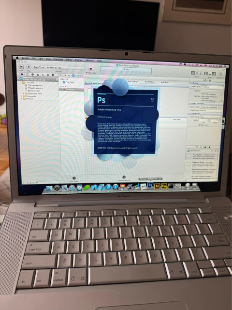 an old macbook pro launching Photoshop CS6 in front of an Xcode project