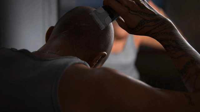 Woman shaving her head while holding trimmer upside down